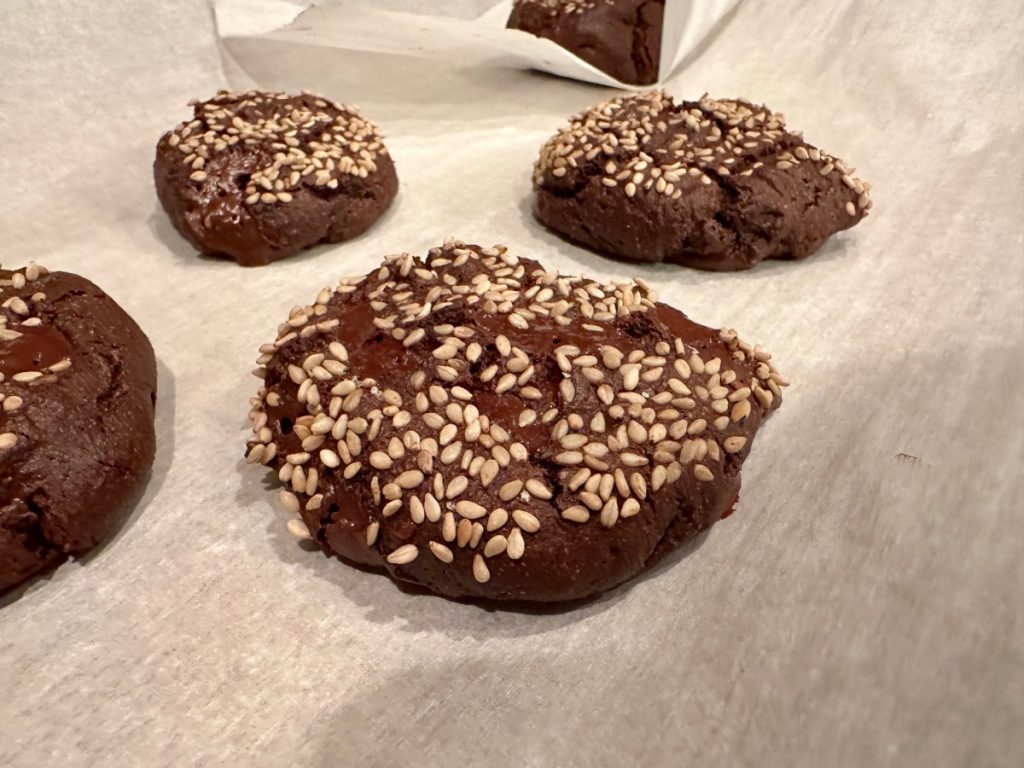 these healthy dark chocolate tahini cookies are coated in sesame seeds