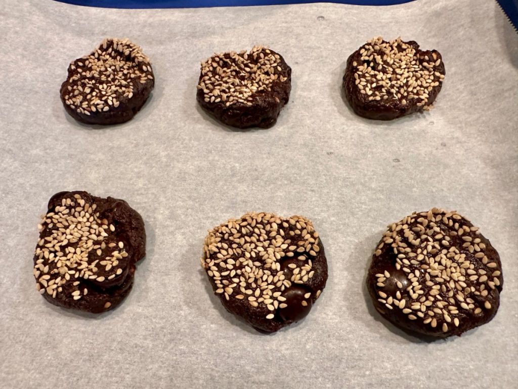 these healthy dark chocolate tahini cookies are coated in sesame seeds