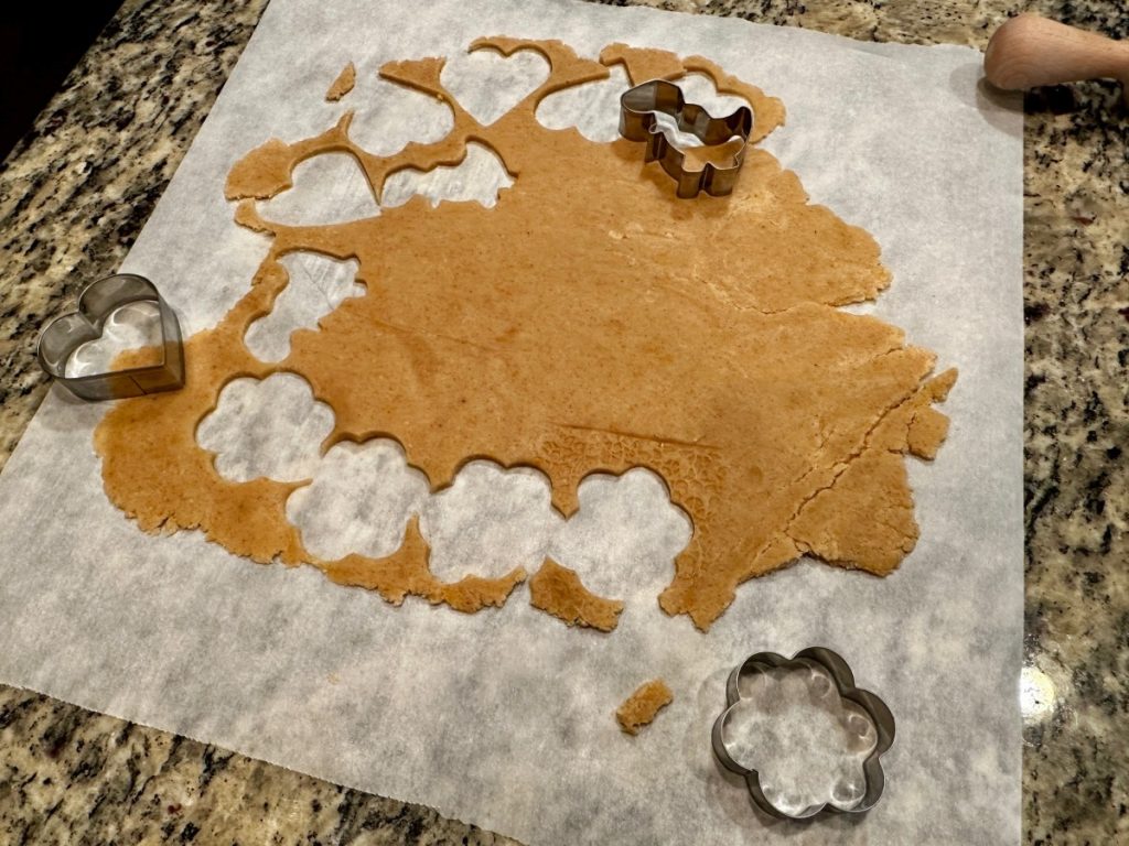cutting out chai spiced shortbread cookies in fun shapes