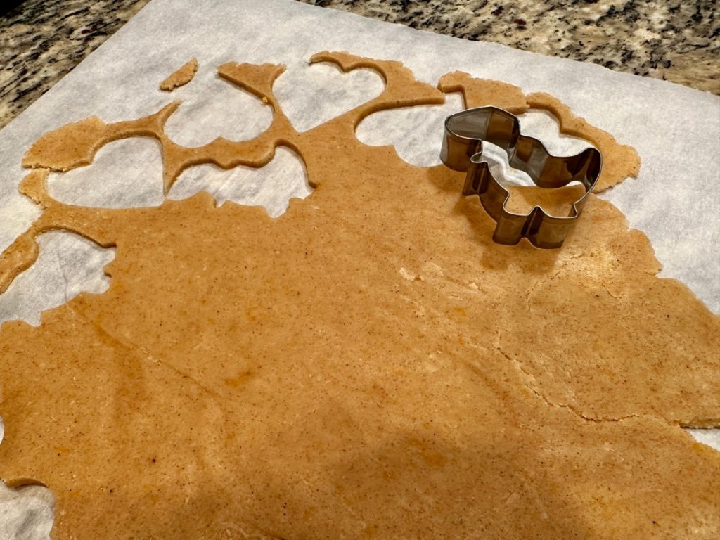 cutting out chai spiced shortbread cookies in fun shapes