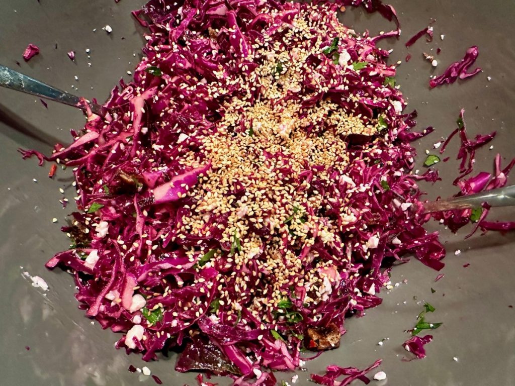 assembling the ingredients for a red cabbage slaw with sesame seeds