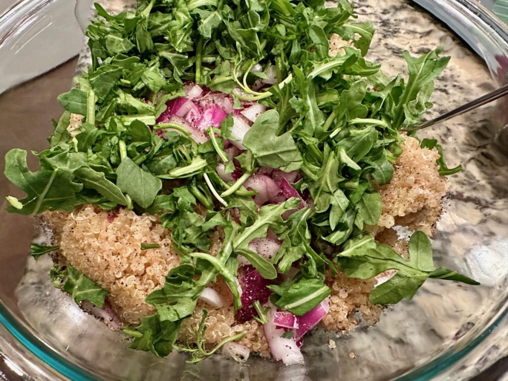 making the arugula red onion quinoa for salmon power bowls