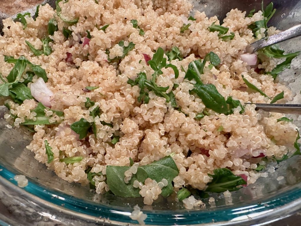 tossing together quinoa, arugula, & red onion to go with our salmon & quinoa power bowls