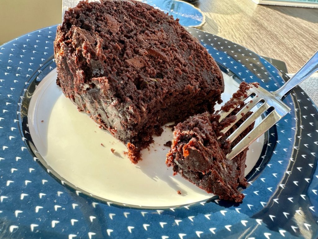 piece of chocolate zucchini cake on a blue and white plate