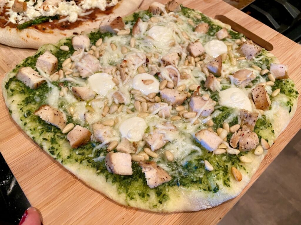 How to Make Grilled Pesto Pizza | Grilled pizza is one of the easiest & most delicious weeknight meals, and pesto pizza is one of my most popular pizza flavor combos.  I strongly believe in using fresh homemade pesto makes this taste so much better!  You can add chicken, pine nuts and more. or just have it be simple pesto and cheese. 