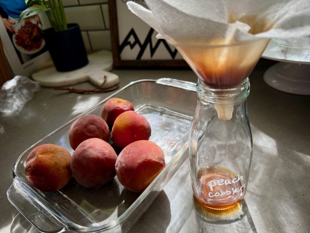 This spiced peach cobbler syrup is sweet and juicy, a perfect way to use summer peaches.  It's full of fruit and spices, and makes an amazing iced coffee or cocktails!  