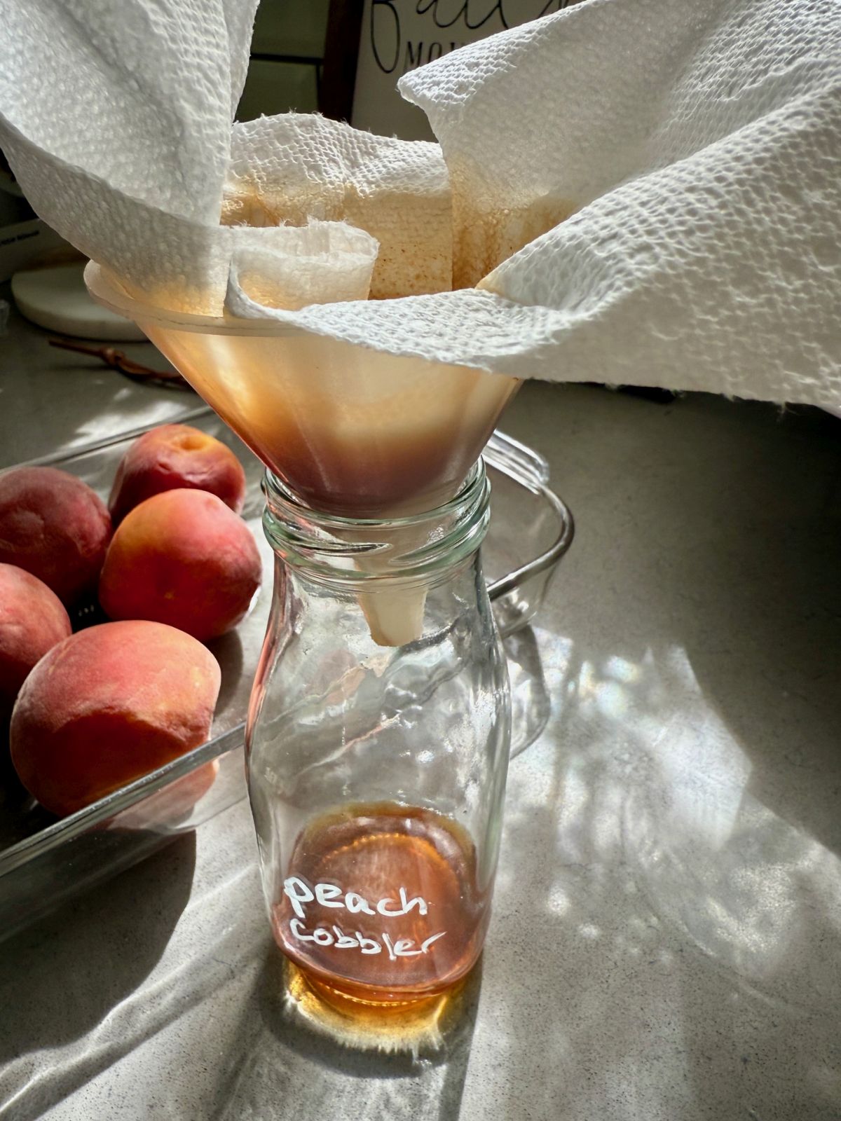 This spiced peach cobbler syrup is sweet and juicy, a perfect way to use summer peaches.  It's full of fruit and spices, and makes an amazing iced coffee or cocktails!  