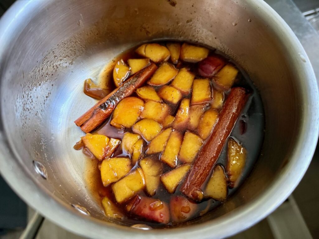 Peach Cobbler Syrup | This spiced peach cobbler syrup is sweet and juicy, a perfect way to use summer peaches.  It's full of fruit and spices, and makes an amazing iced coffee or cocktails!  This peach simple syrup only takes a few minutes to make, it's super easy.  
