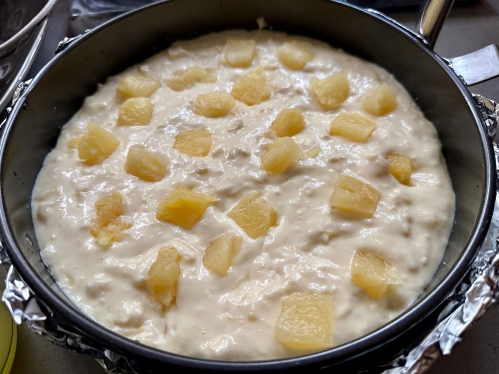 Refreshing Pineapple Cheesecake with Macadamia Shortbread Crust | This Hawaiian-inspired baked cheesecake is really easy to make, and a perfect make-ahead dessert (since it needs to chill several hours).  It's subtle and not super sweet, with an amazing creamy texture and crumbly shortbread crust.  This is perfect any time of year, a great summer dessert or a spot of sunshine as a winter dessert.  #cheesecake #pineapple #makeahead #dessertrecipes