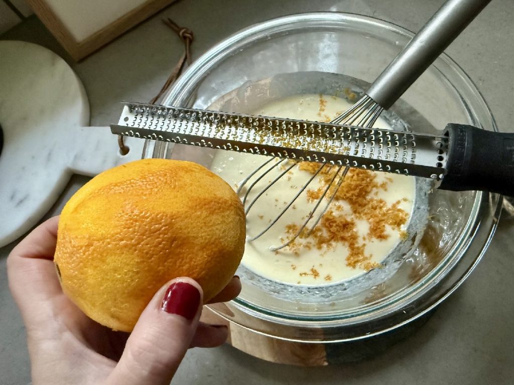 zesting an orange for orange poppyseed pancakes