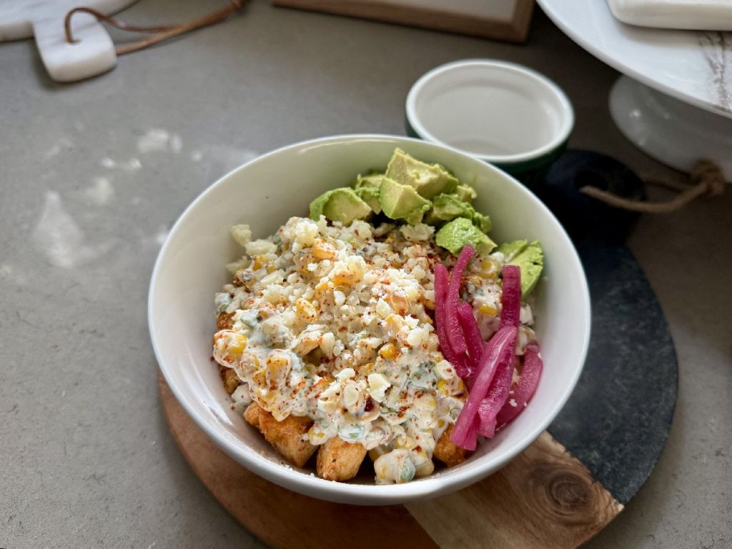 mexican street corn chicken bowls with red onion garnish