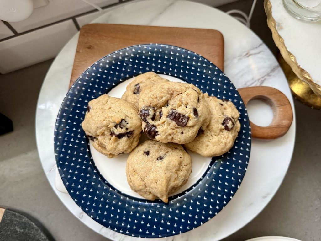 dark chocolate chunk orange tahini cookies on a navy blue plate